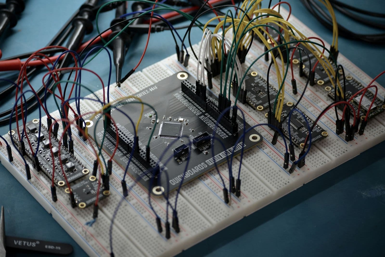 A development board on a breadboard, wired out to several sensor modules.