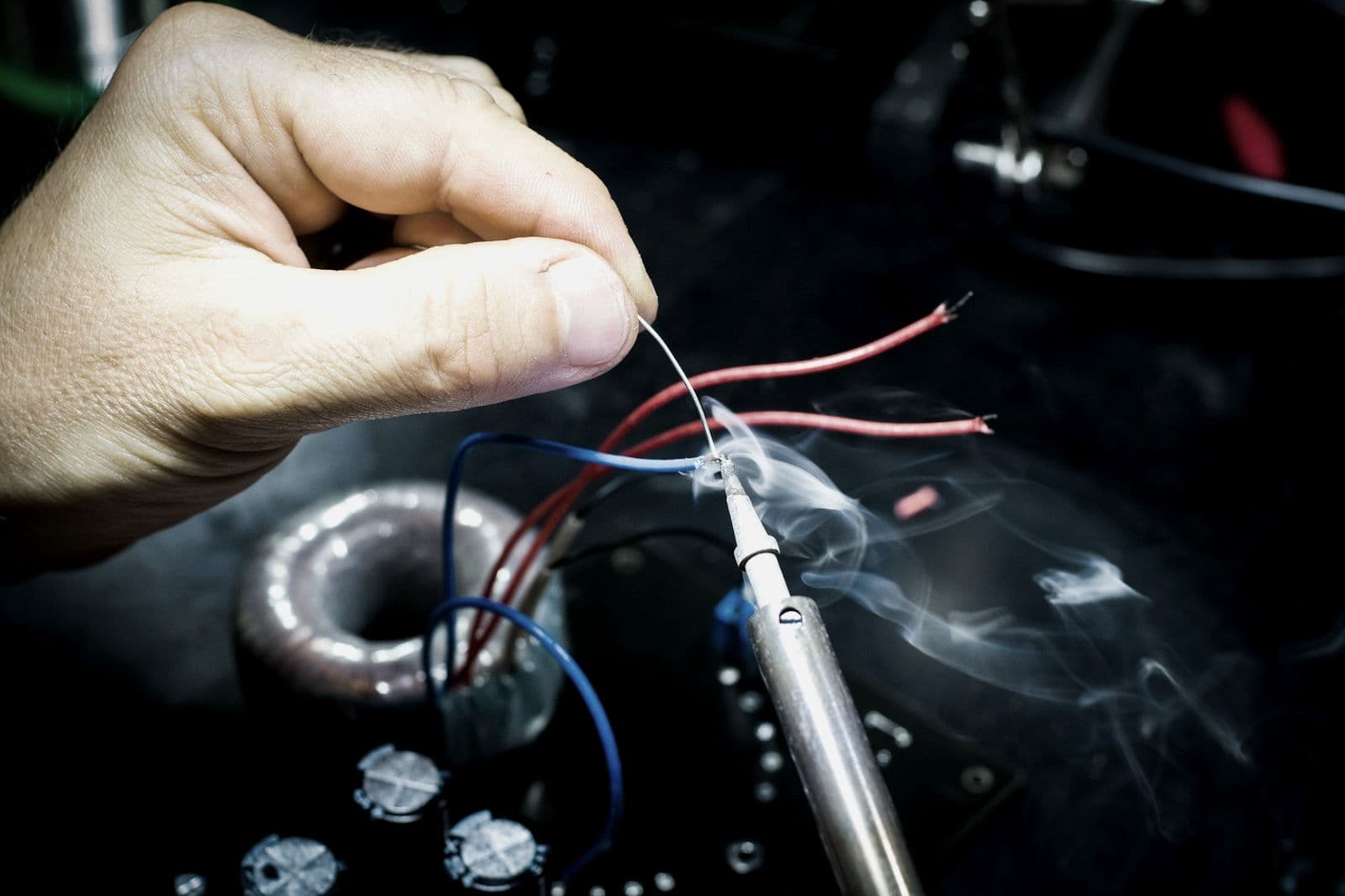 Joining wires with solder over a toroidal coil.